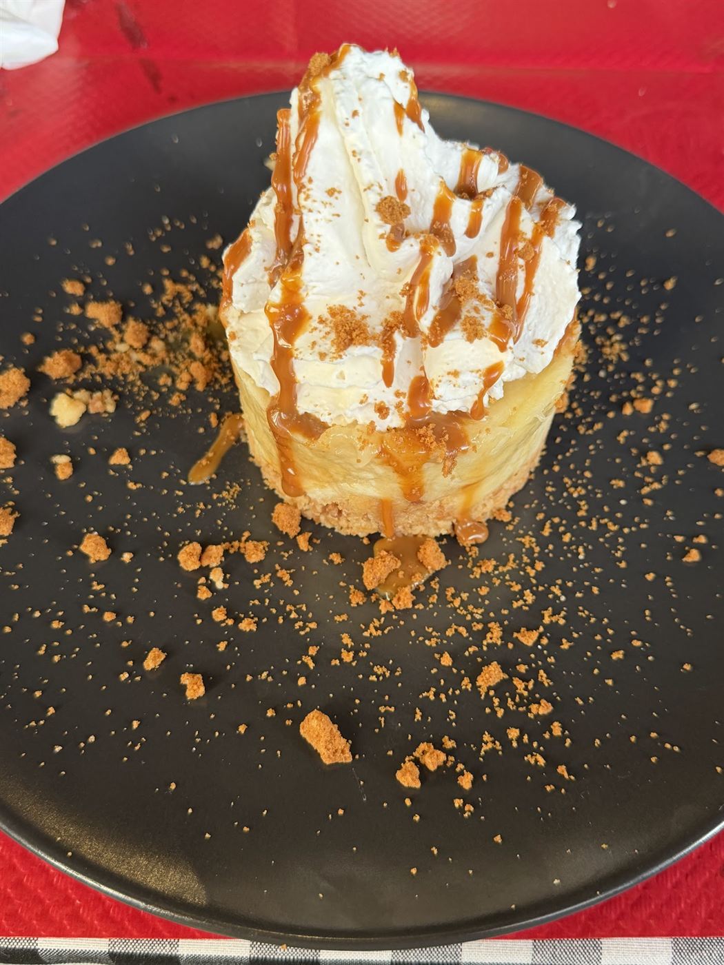 Dessert gourmand : chantilly, caramel et crumble sur une assiette noire