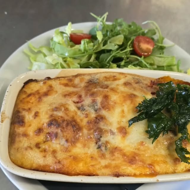 Lasagnes gratinées servies avec une salade de roquette