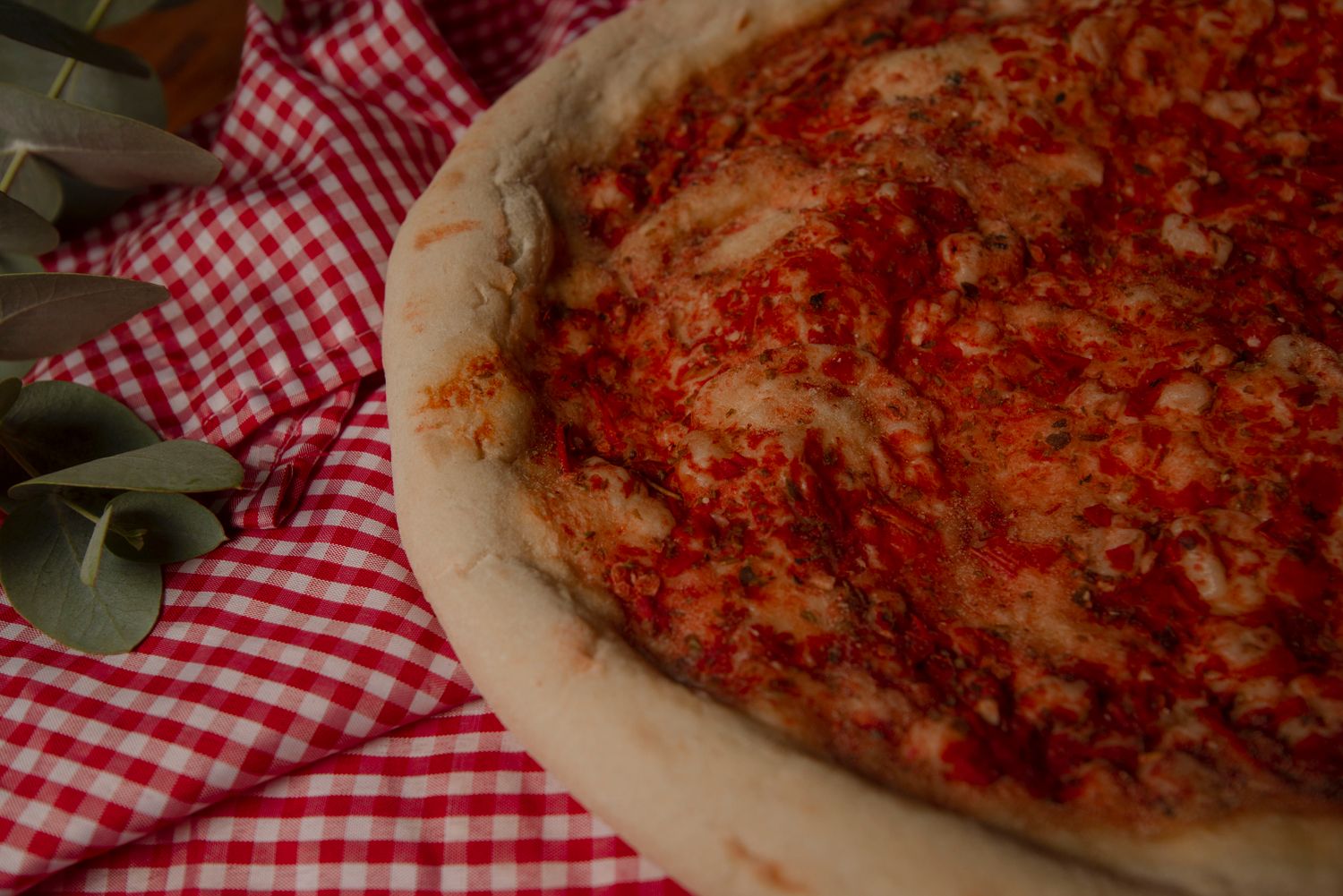 Pizza sur une nappe à carreaux rouge et blanc